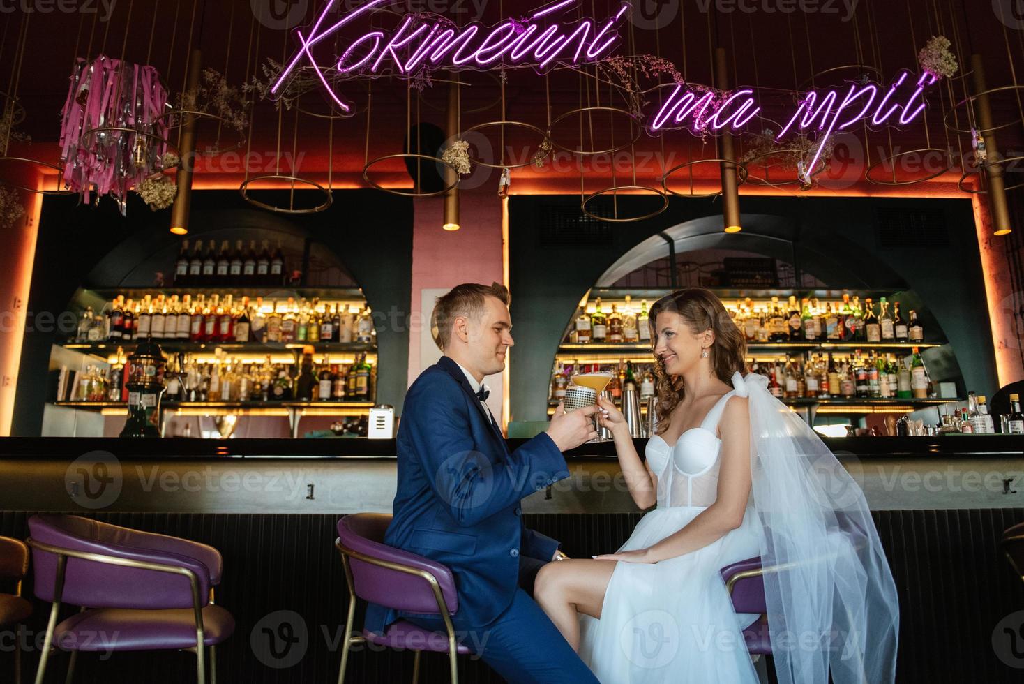 bride and groom inside a cocktail bar photo