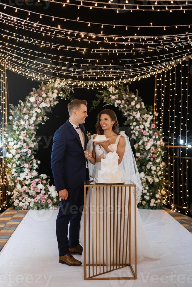 newlyweds happily cut and taste the wedding cake photo