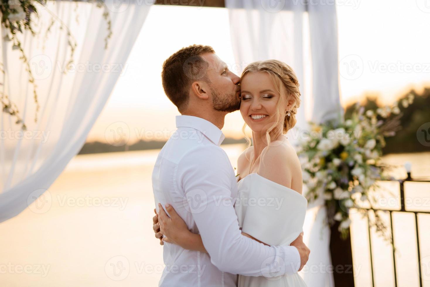bride and groom against the backdrop of a yellow sunset photo