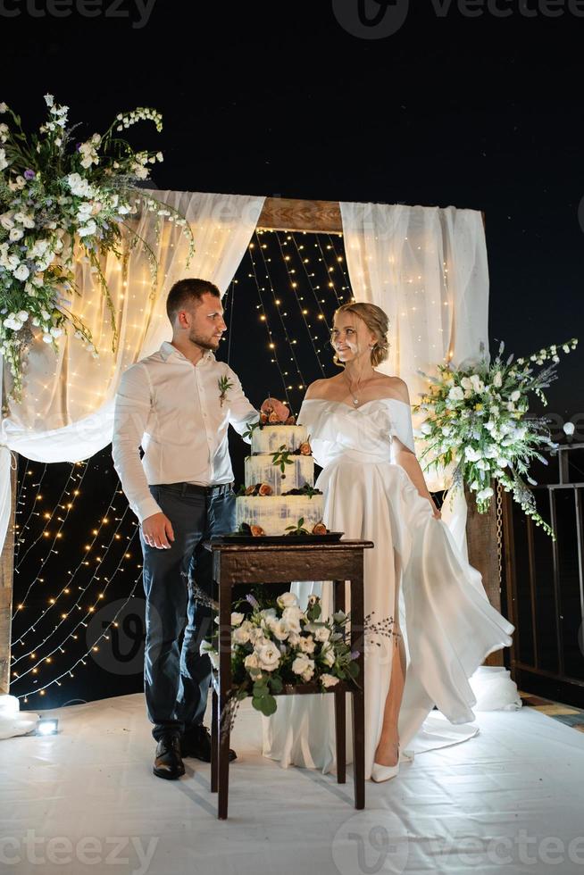 newlyweds happily cut and taste the wedding cake photo