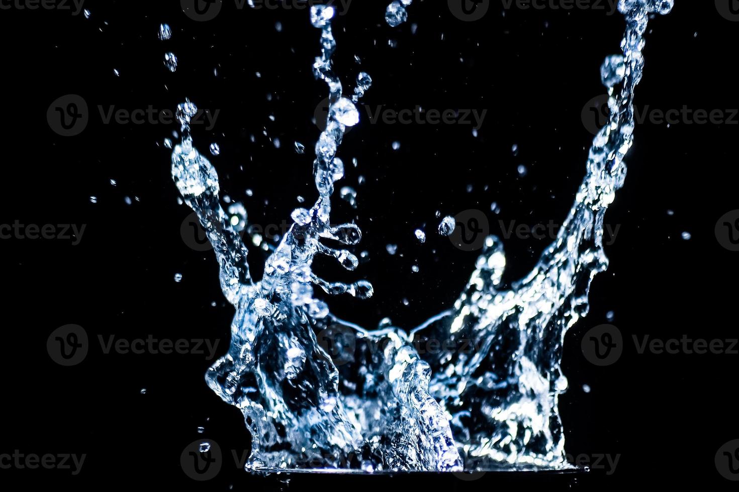 Splashing water on a black background. water droplets scattered on a black background photo