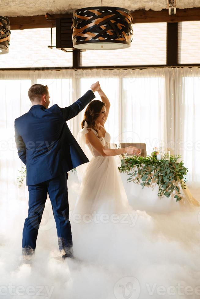 the first dance of the bride and groom inside a restaurant photo