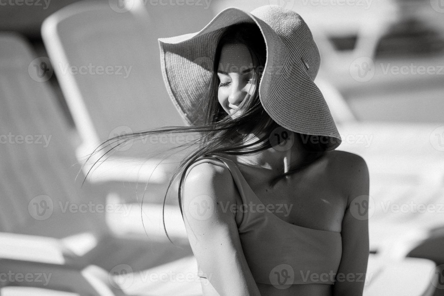 niña en un Paja sombrero y un rosado baños traje país piscina foto