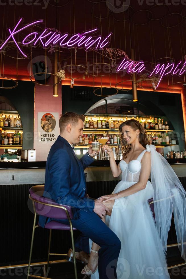 bride and groom inside a cocktail bar photo