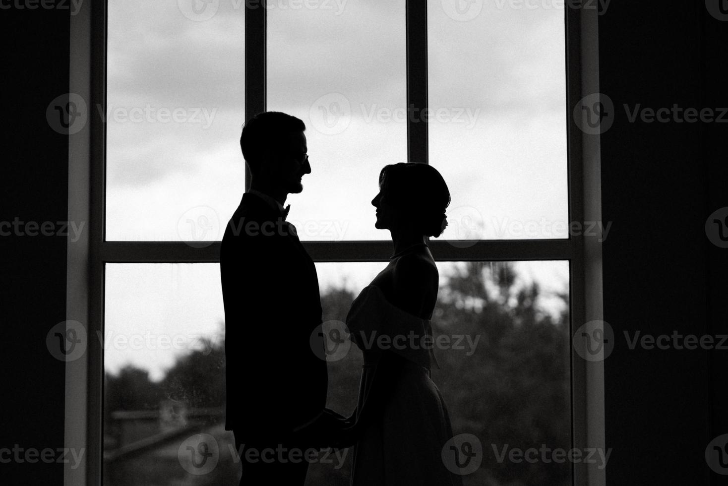 groom in a black suit tie and the bride in a bright studio photo