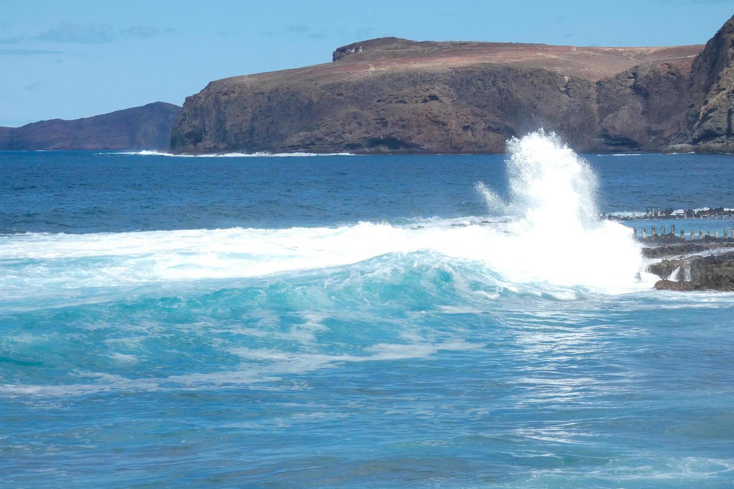 Large waves crashing against the rocks in the ocean photo
