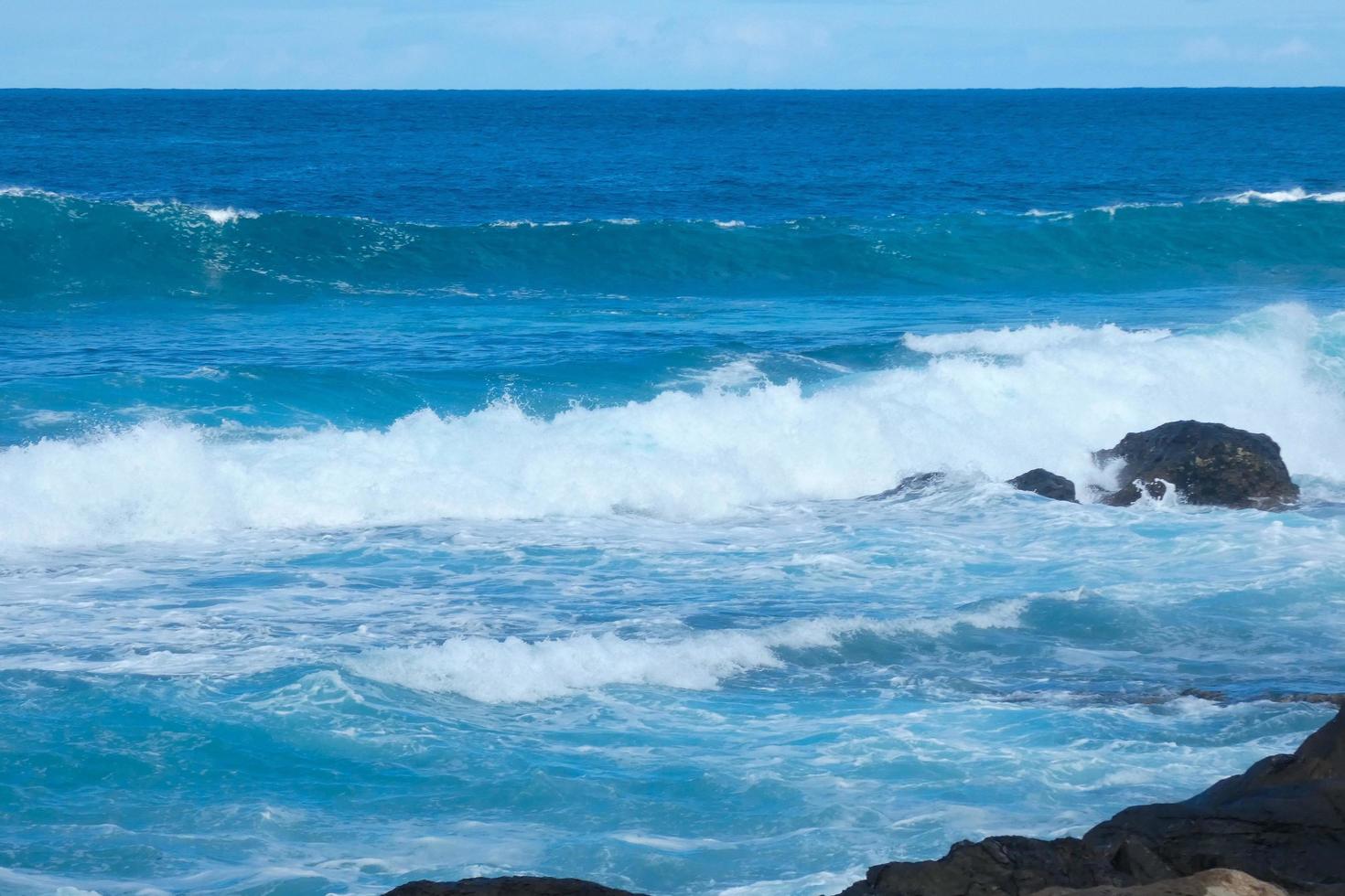 Large waves crashing against the rocks in the ocean photo