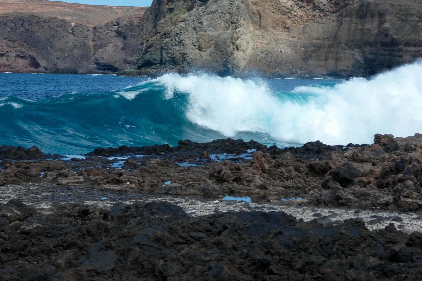 Large waves crashing against the rocks in the ocean photo