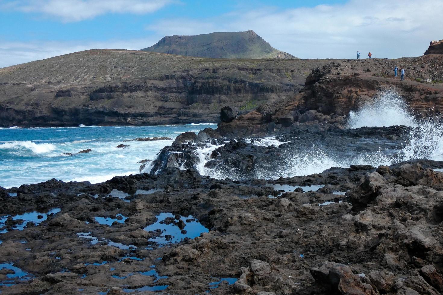 Large waves crashing against the rocks in the ocean photo