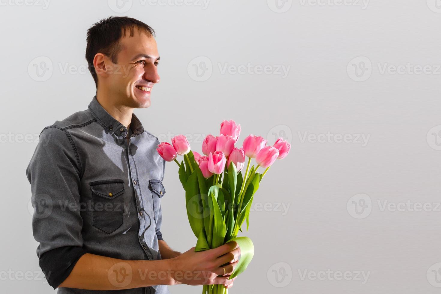 Man with flowers. Romantic Man with bouquet of tulips for birthday. Happy woman's day. Giving bouquet of flowers. Handsome man giving flowers. White background. Horizontal photo.s photo