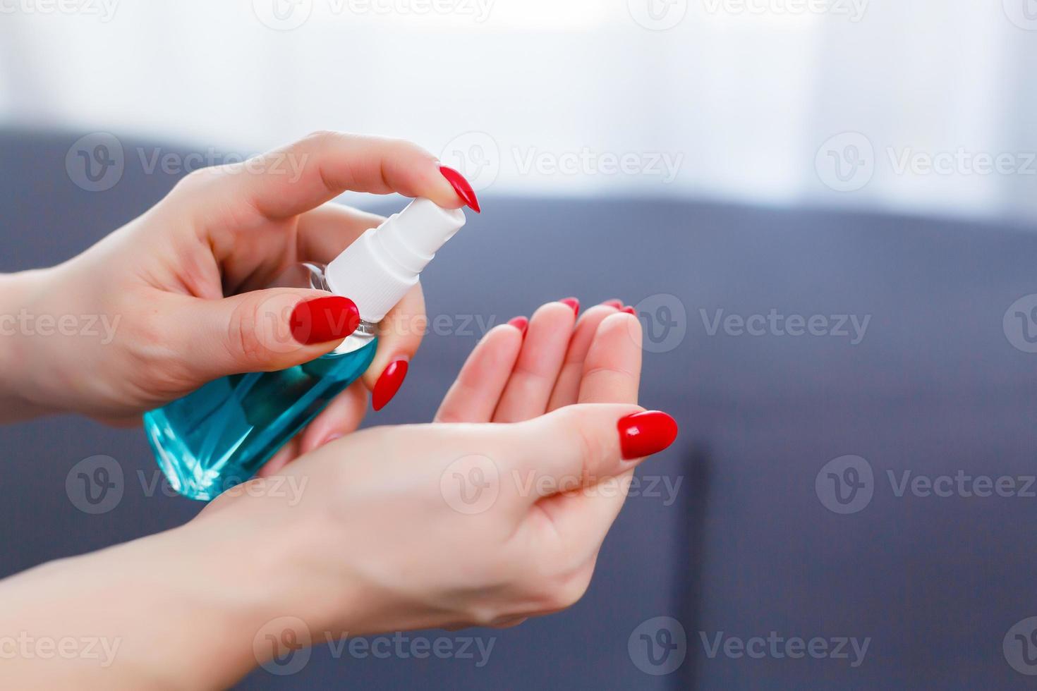 Using antibacterial spray for hands. People, healthcare and hygiene concept. Coronavirus protection. photo