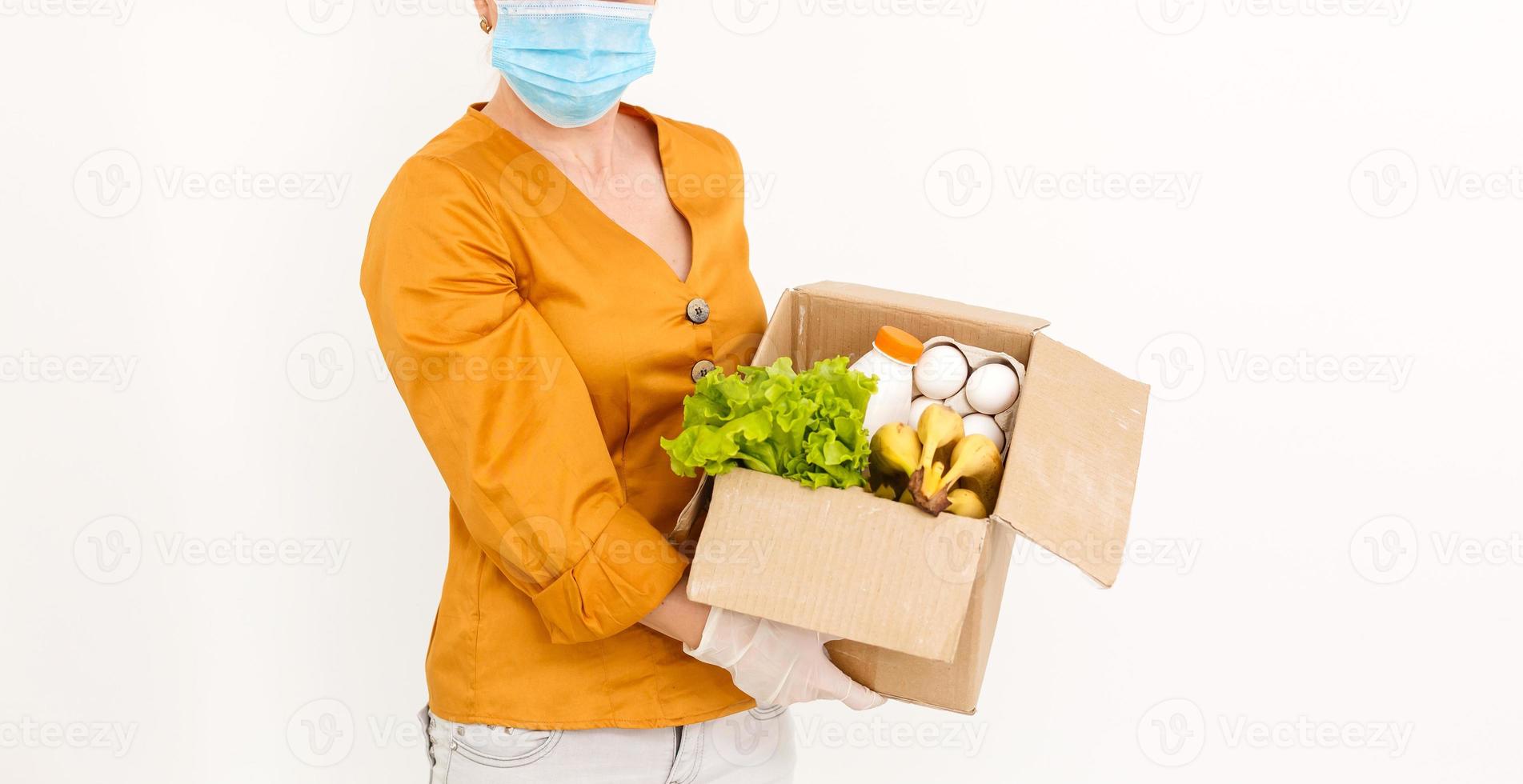 Delivery Concept Caucasian grocery delivery courier man with grocery box with fresh fruit and vegetable photo