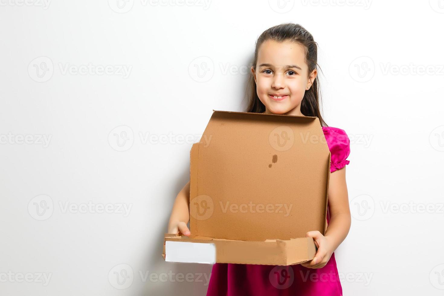 contento pequeño niña con Pizza en un papel caja foto