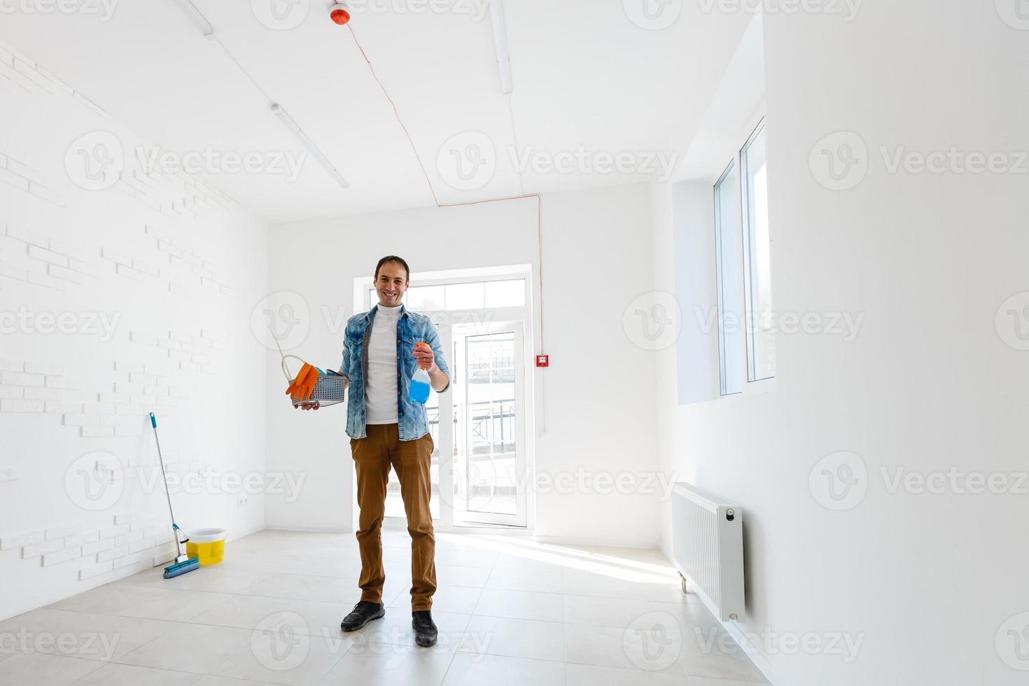 portrait of man with cleaning equipment cleaning the house photo
