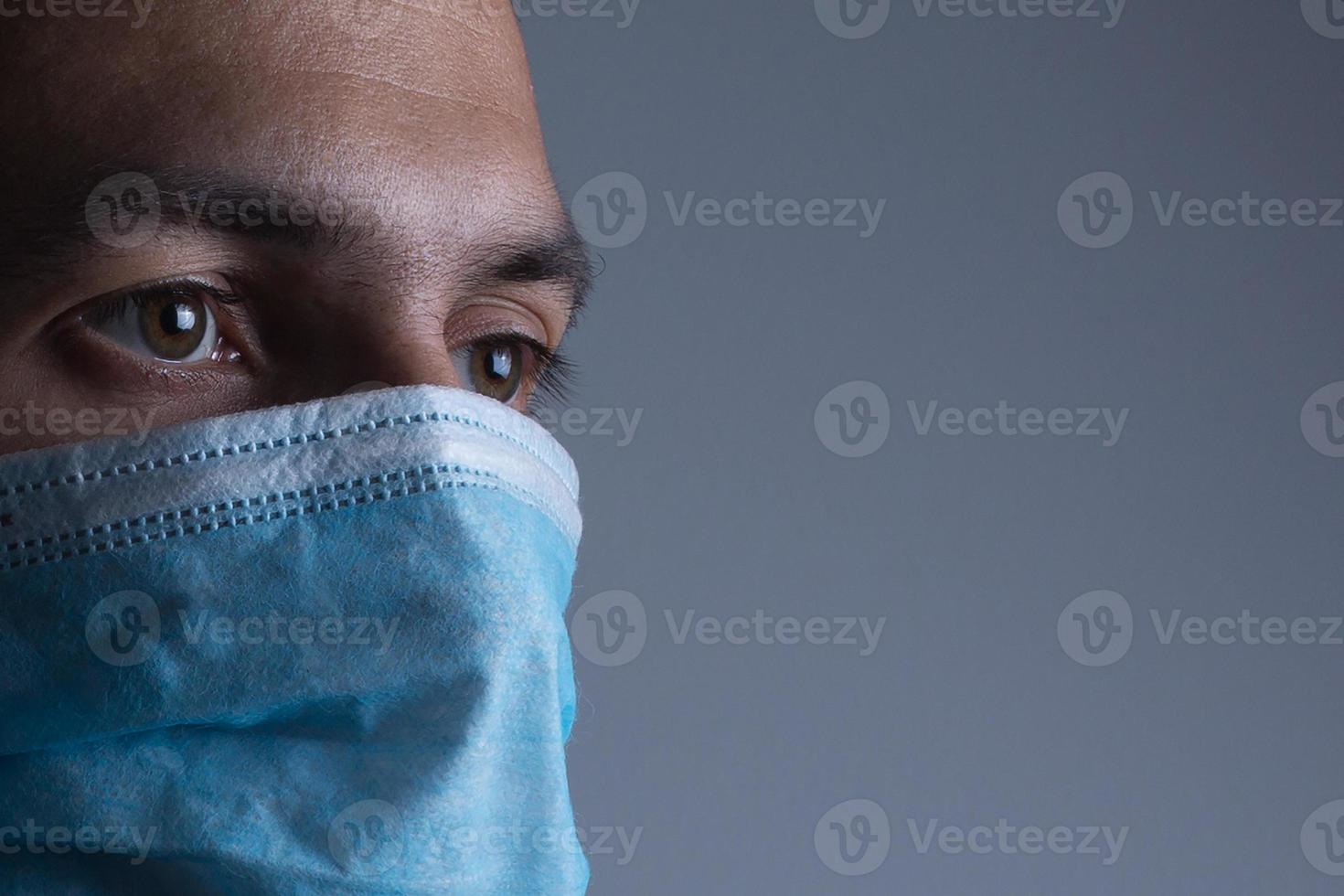 Strong man wearing mask to prevent flu virus and dust air pollution on white background photo