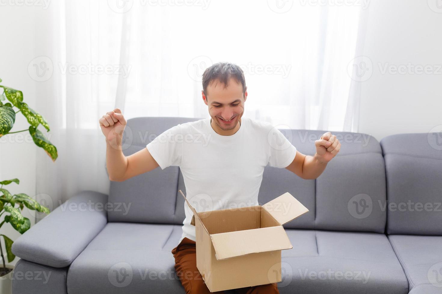 Happy man with an open box in an apartment photo