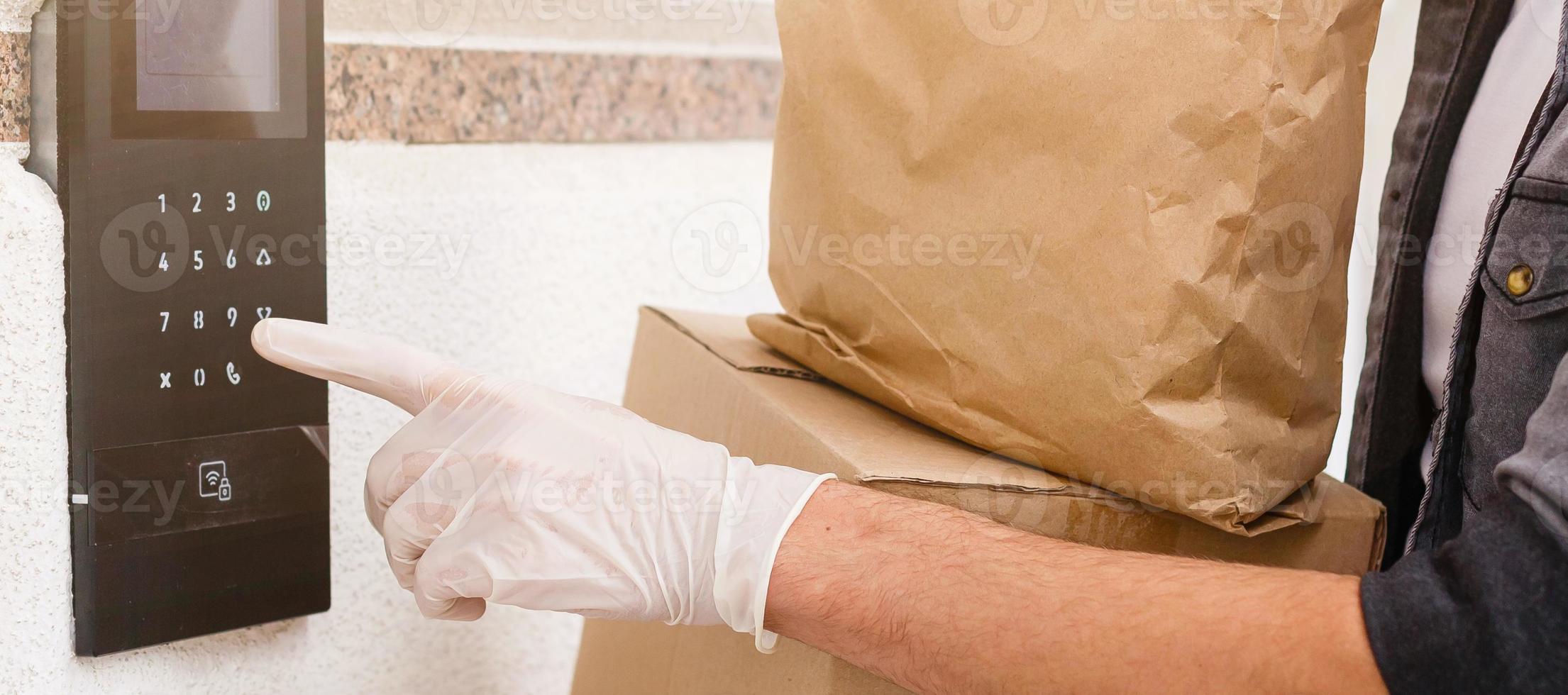 Courier in protective mask and medical gloves delivers takeaway food. Delivery service under quarantine, disease outbreak, coronavirus covid-19 pandemic conditions. photo