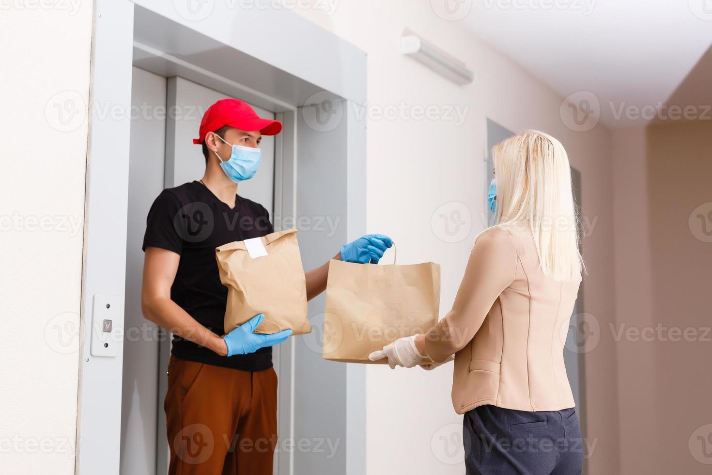 Parcel delivery at home. new coronavirus 2019-nKoV. Young woman wearing a medical mask receiving a package. Virus Prevention photo