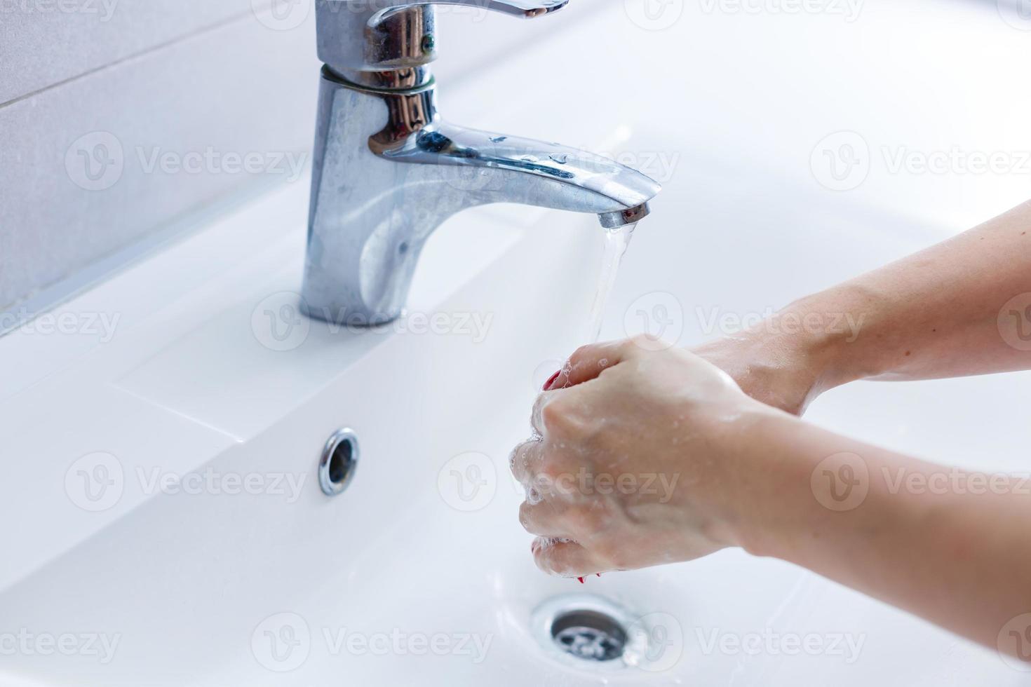 woman washes hands white wash basin photo