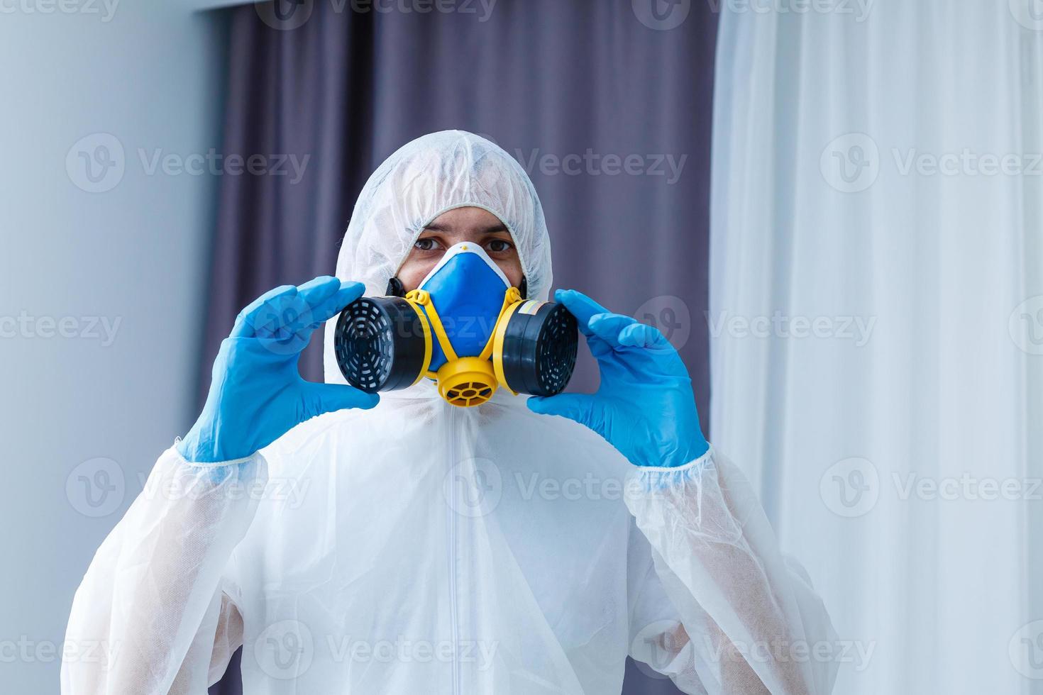 Man in protective clothing and a gasmask on a white background photo