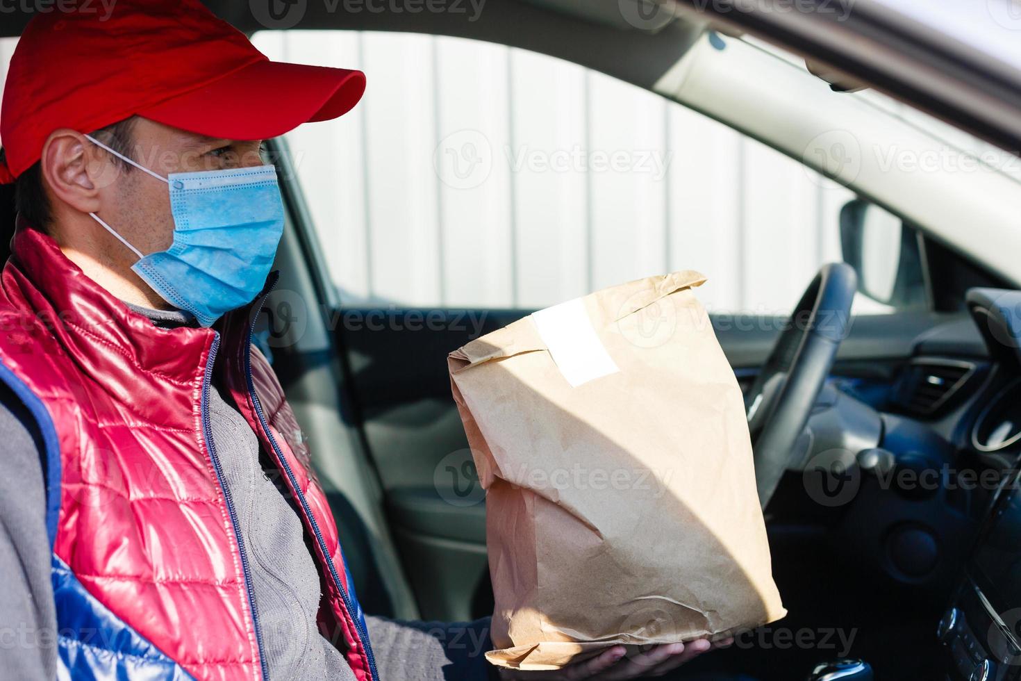 delivery man delivers orders by car. Delivery service under quarantine, disease outbreak, coronavirus covid-19 pandemic conditions. photo