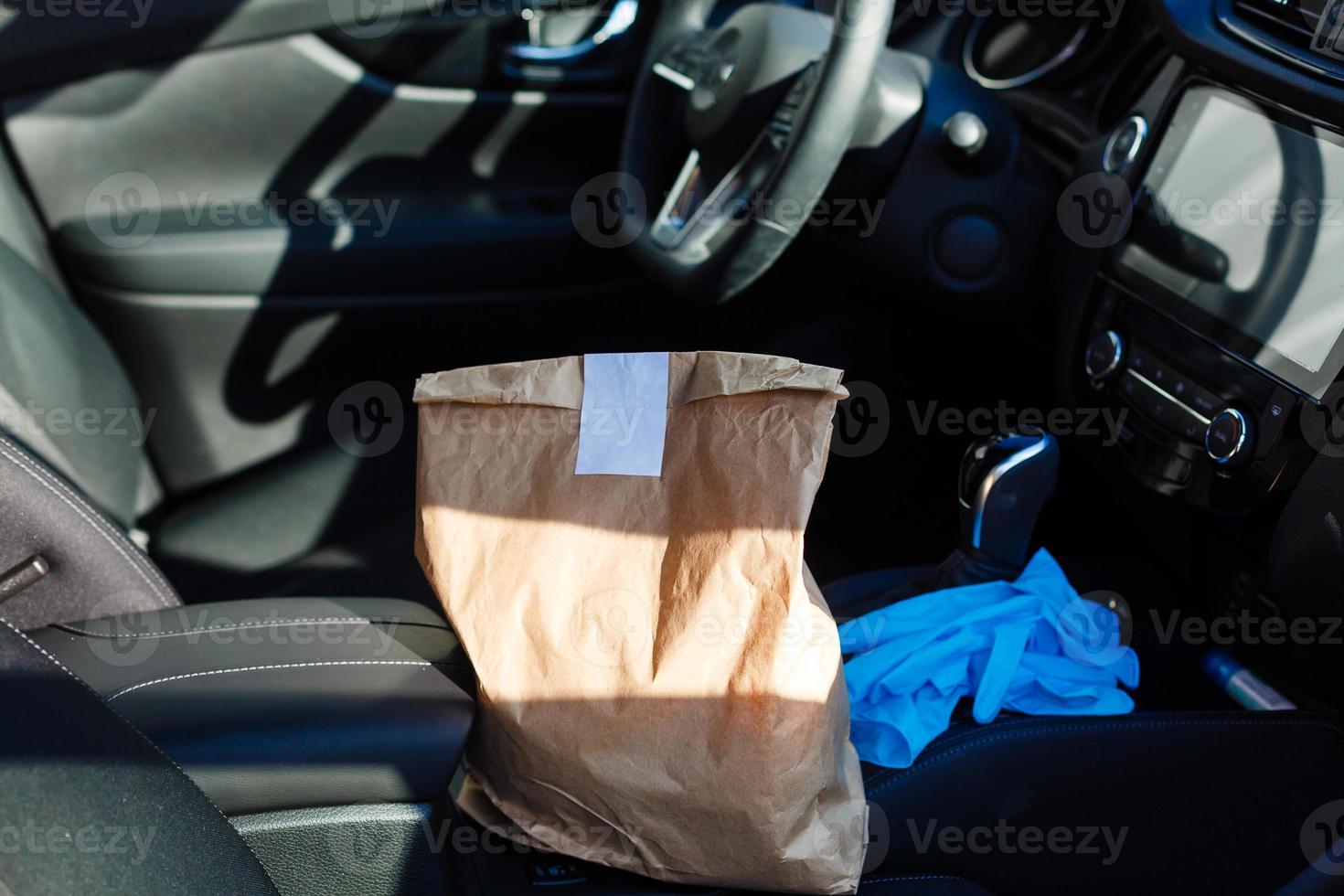 delivery by car. man in protective mask and medical gloves holding a paper box. Delivery service under quarantine, disease outbreak, coronavirus covid-19 pandemic conditions. photo