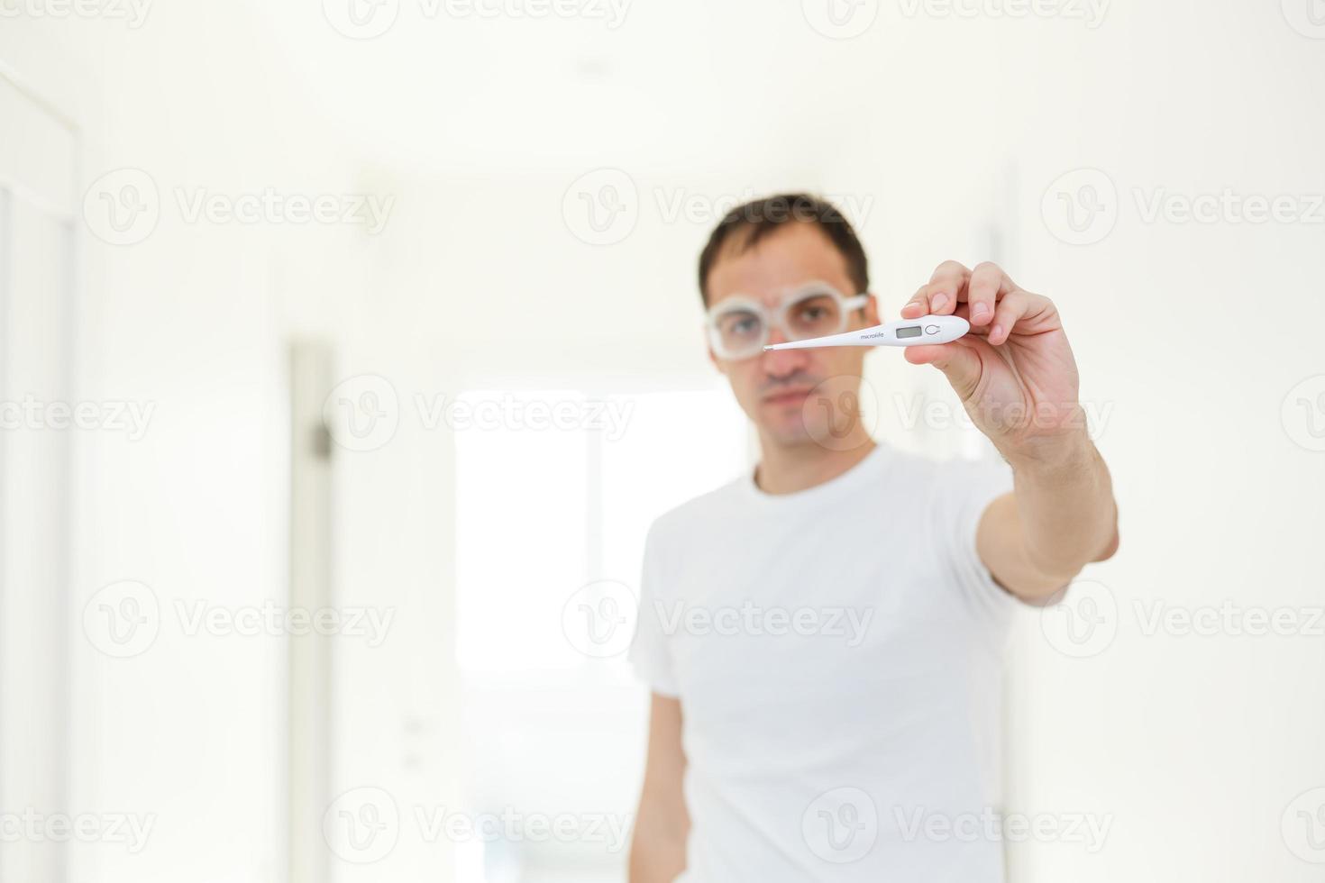 people, healthcare and fever concept, man, thermometer over grey background photo