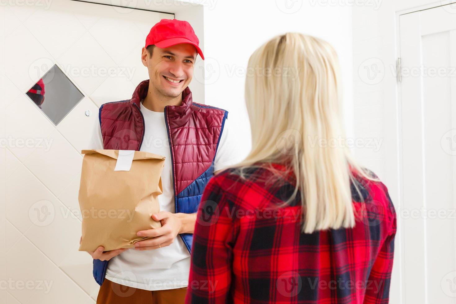 joven hermoso hombre entregando comida en un Departamento foto