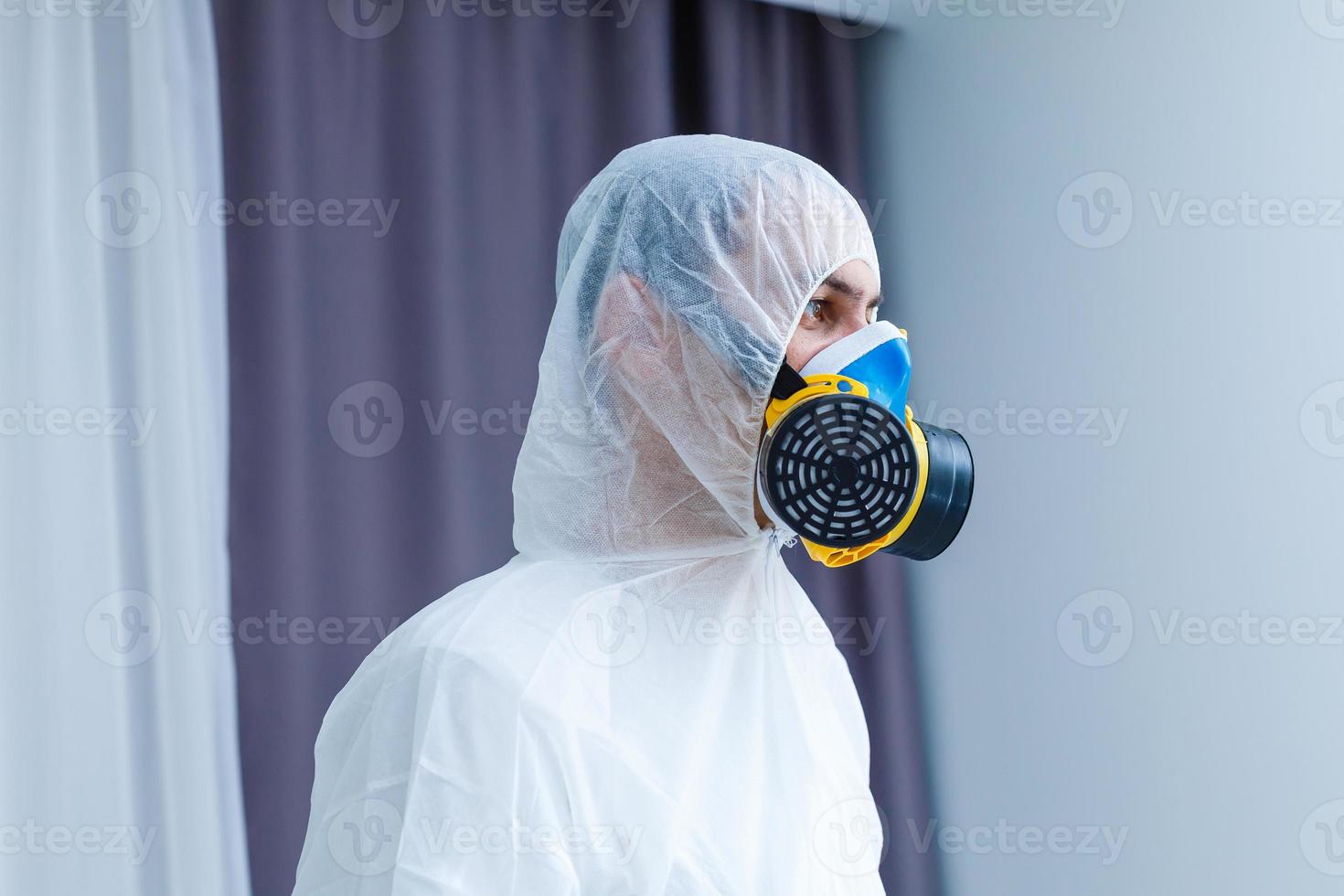 Man in protective clothing and a gasmask on a white background photo