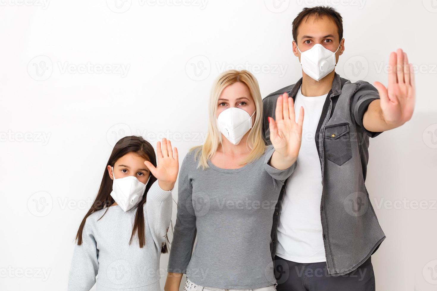 family in protective masks quarantined. Normal life with coronavirus. Lifestyle COVID-19. Quarantine virus protection sterility home together heart symbol photo