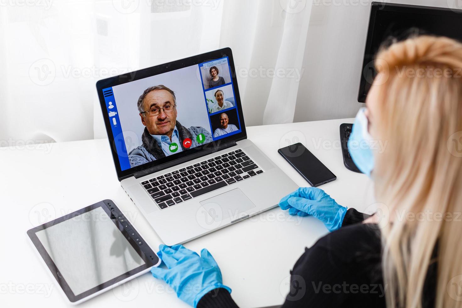 maestro, tutor o profesor con auriculares, ordenador portátil y cámara en su oficina explicando alguna cosa a un en línea lección o vídeo conferencia, seminario web foto