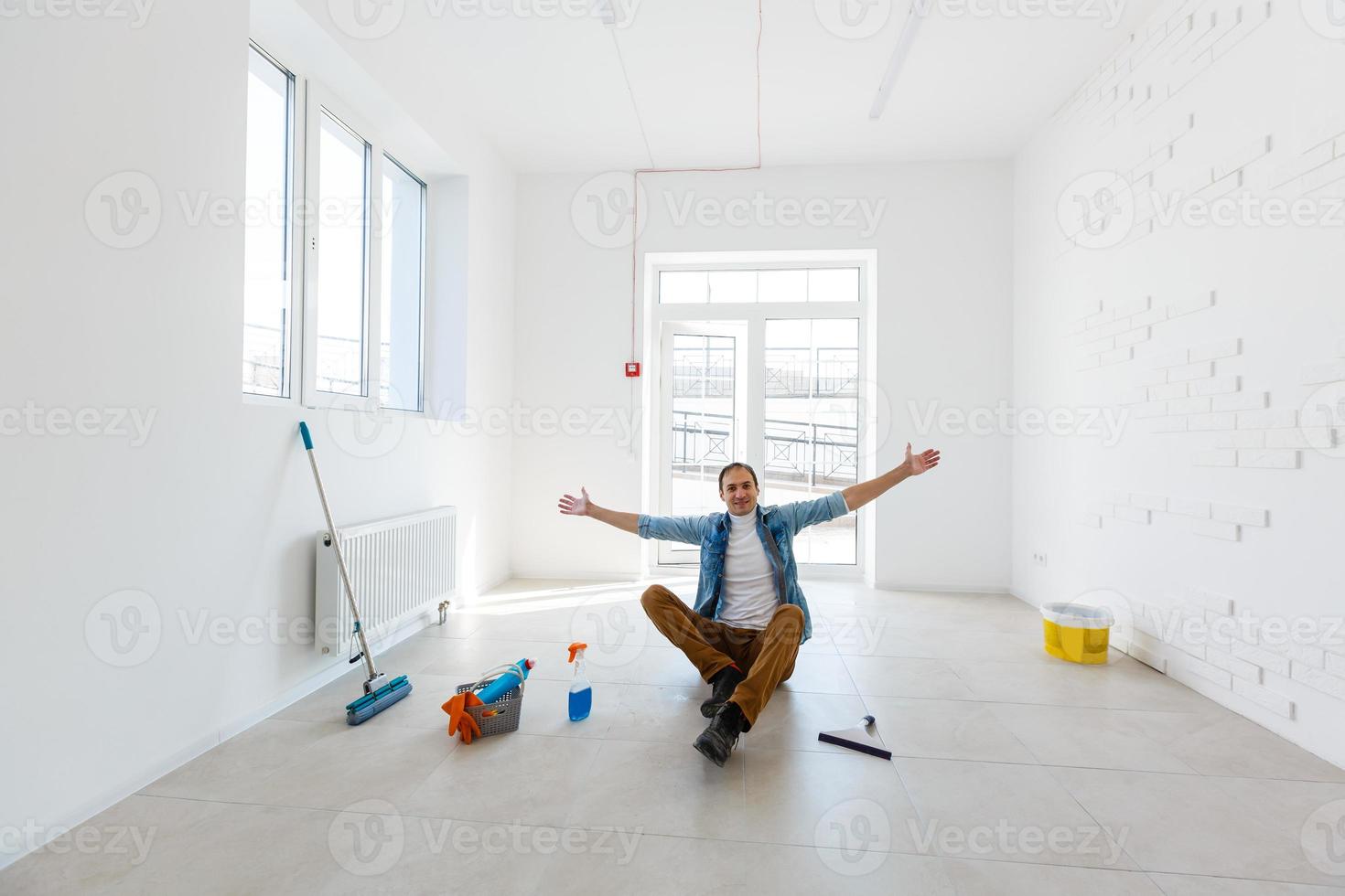 portrait of man with cleaning equipment cleaning the house photo