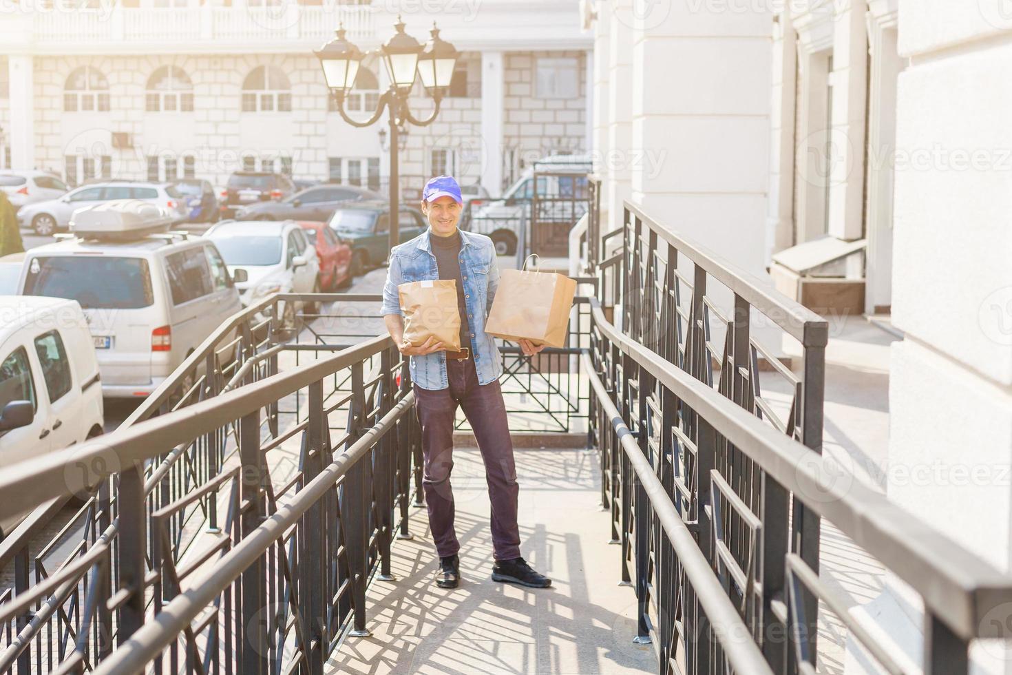 delivery, mail and people concept - man delivering coffee and food in disposable paper bag to customer home photo