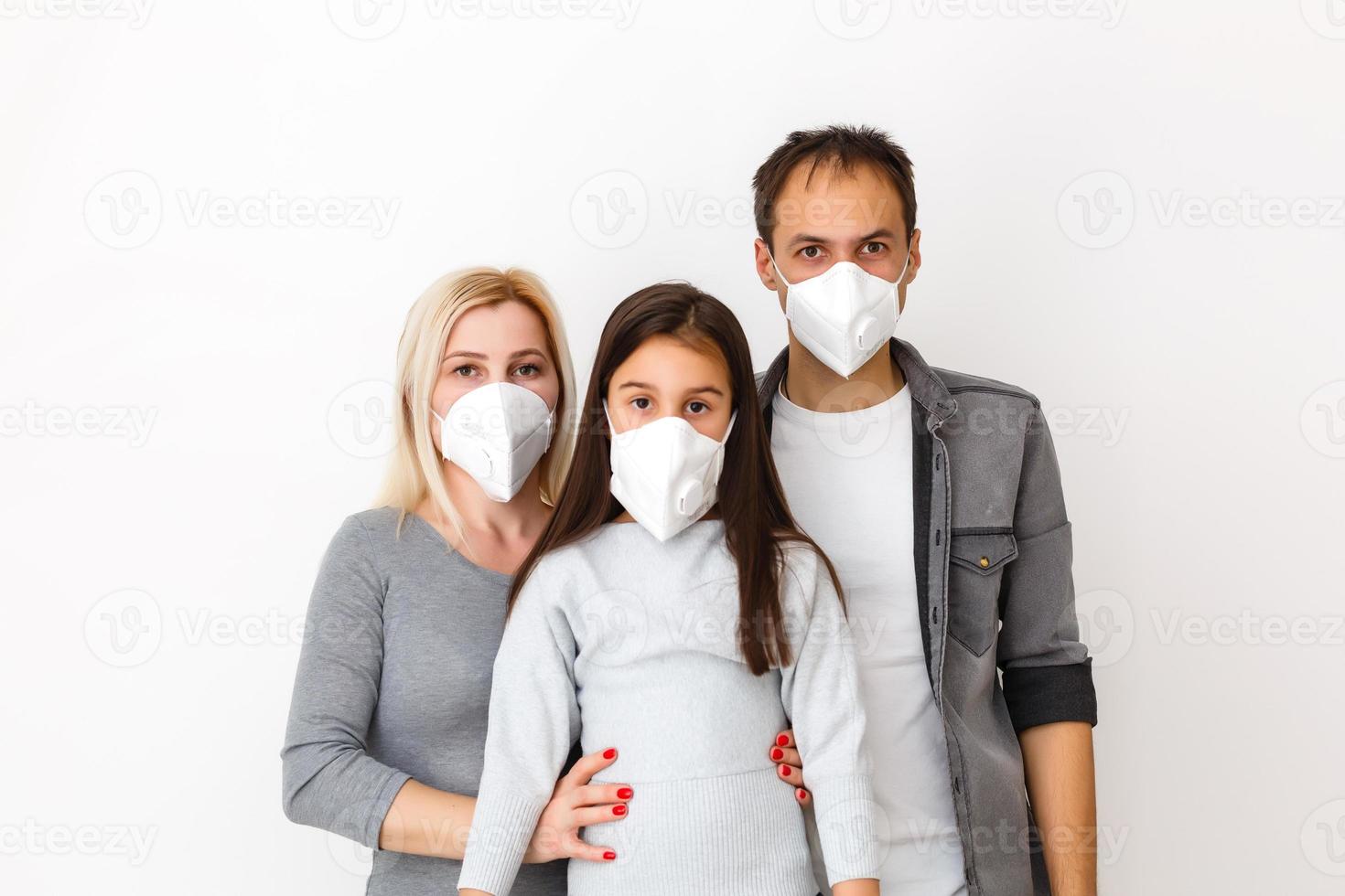 family in protective masks quarantined. Normal life with coronavirus. Lifestyle COVID-19. Quarantine virus protection sterility home together heart symbol photo