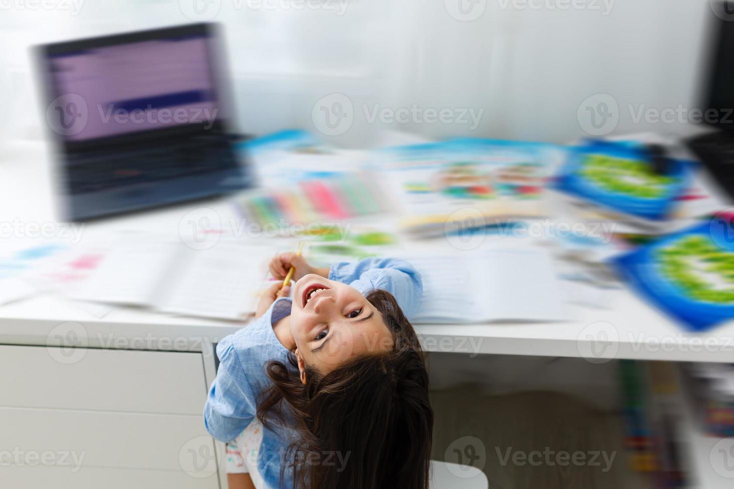 education and school online concept - smiling little student girl with many books at home schooling photo