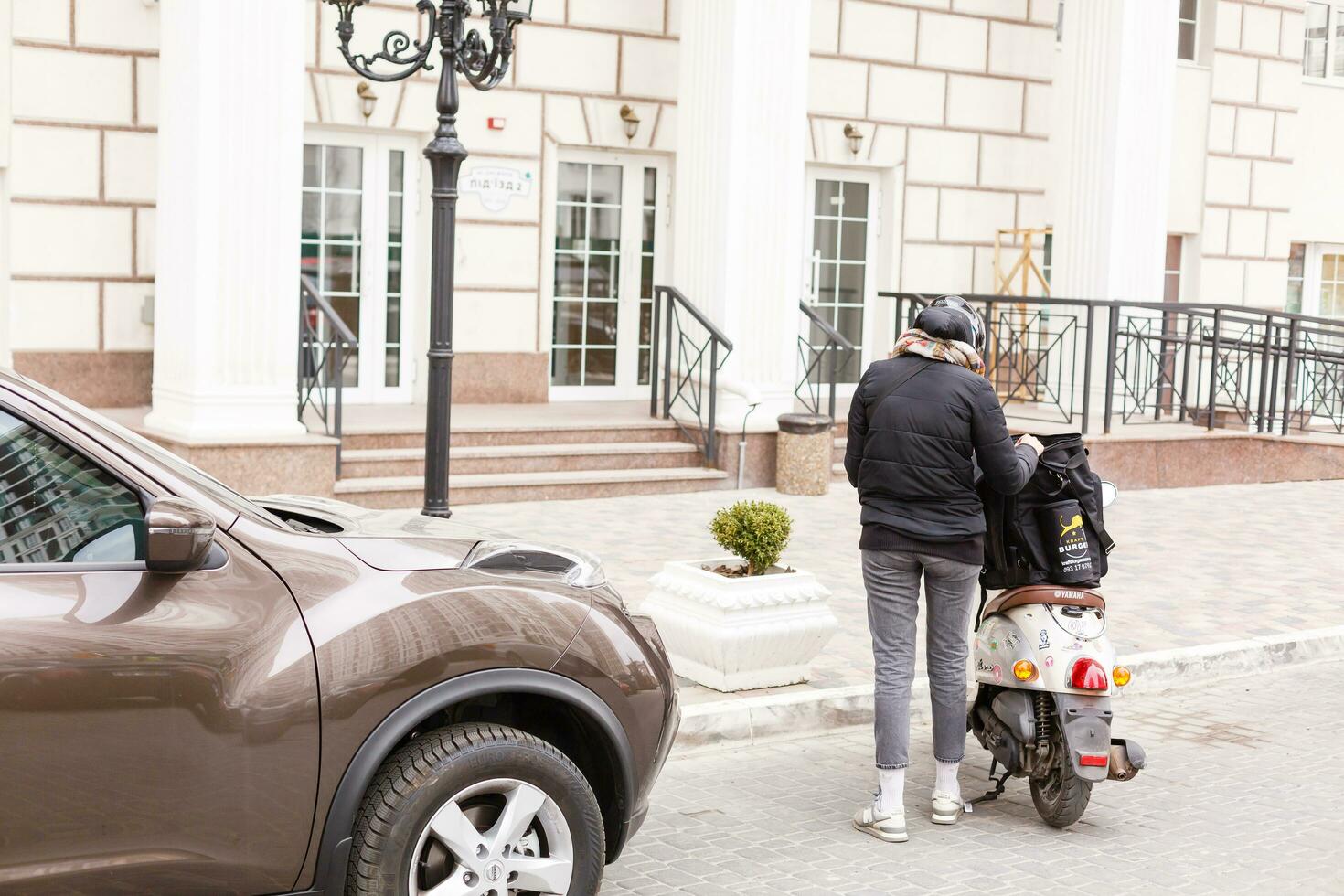 enmascarado mujer entregando comida en un motocicleta foto