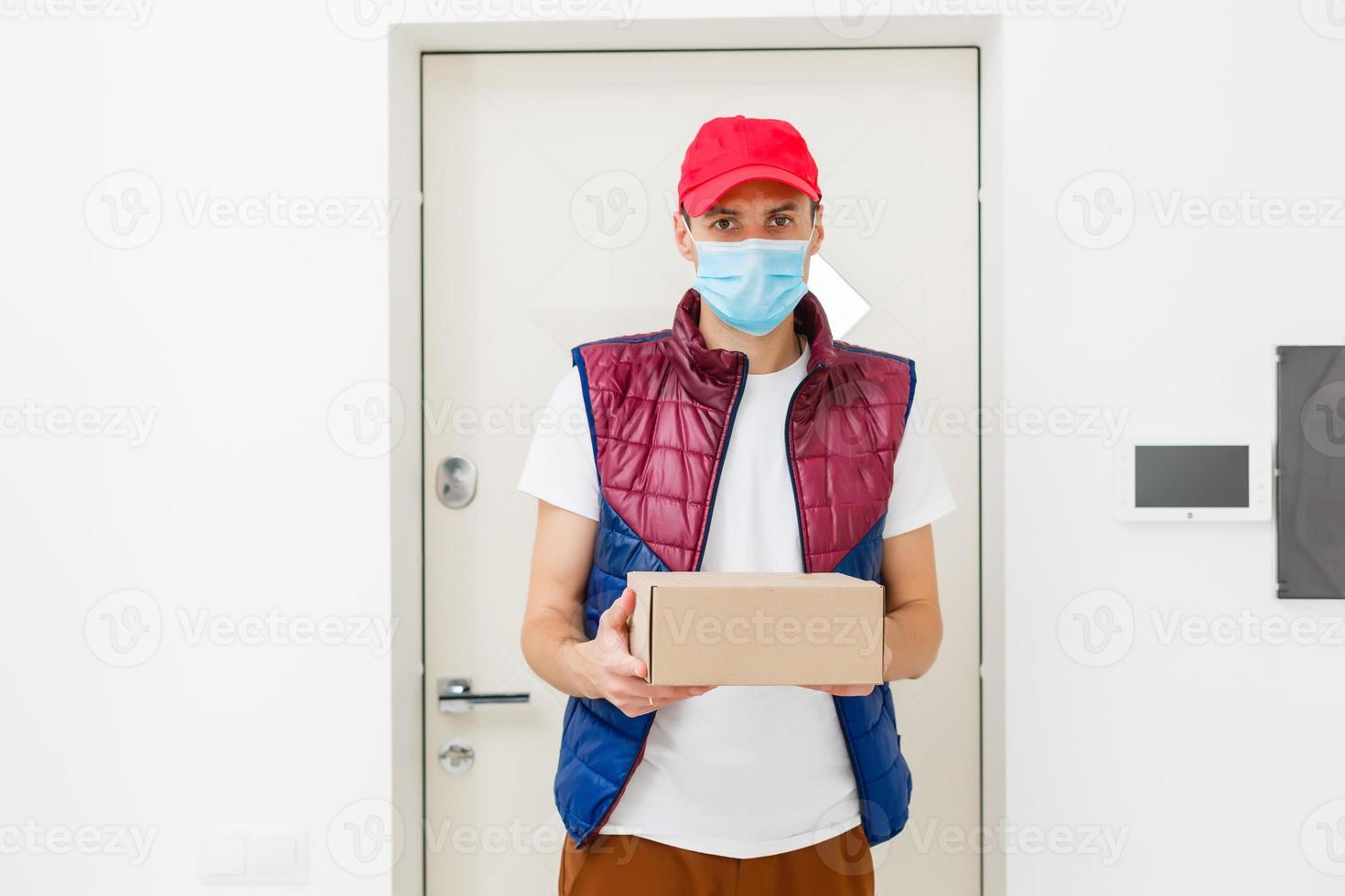 Delivery man holding paper bag with food on white background, food delivery man in protective mask photo