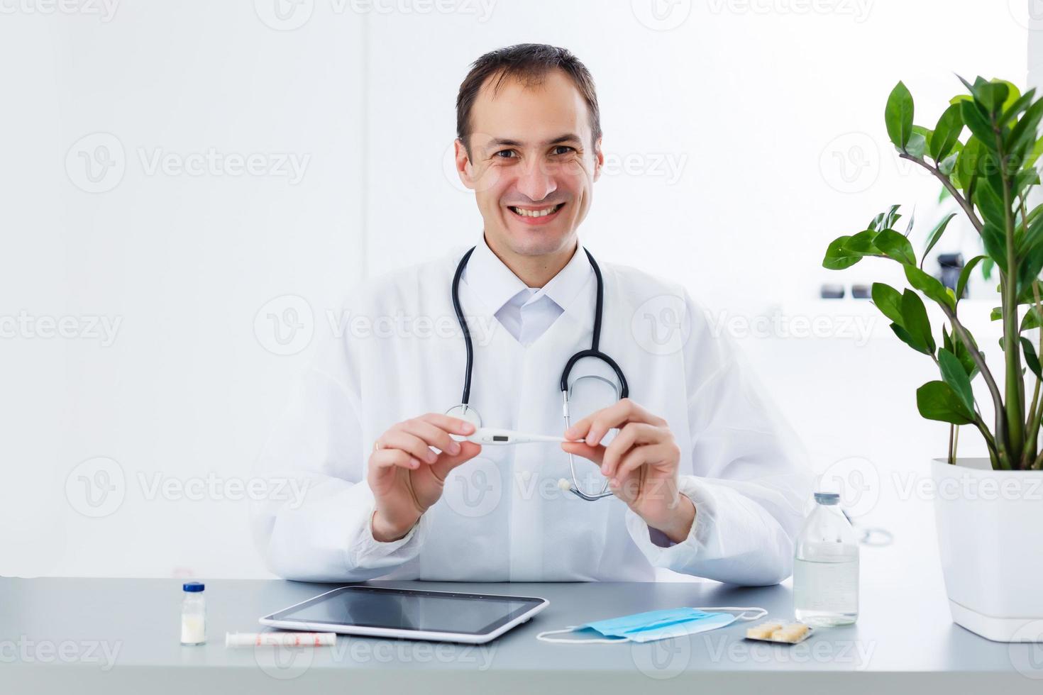 Young male doctor with tablet in office photo