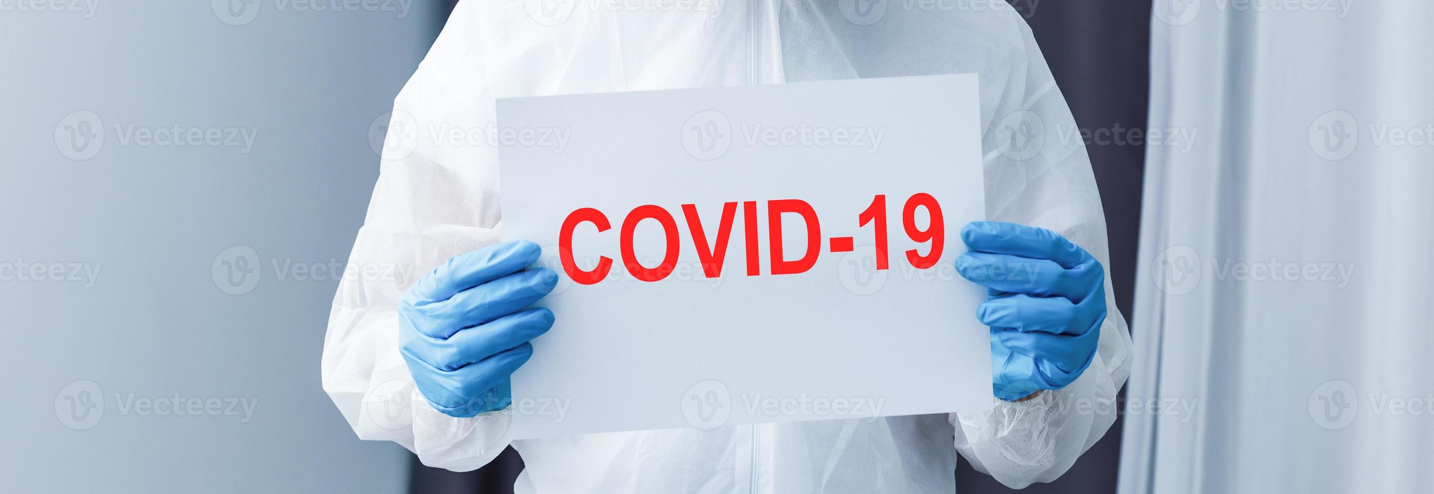 Man wearing chemical protective suit on light grey background. Coronavirus outbreak photo