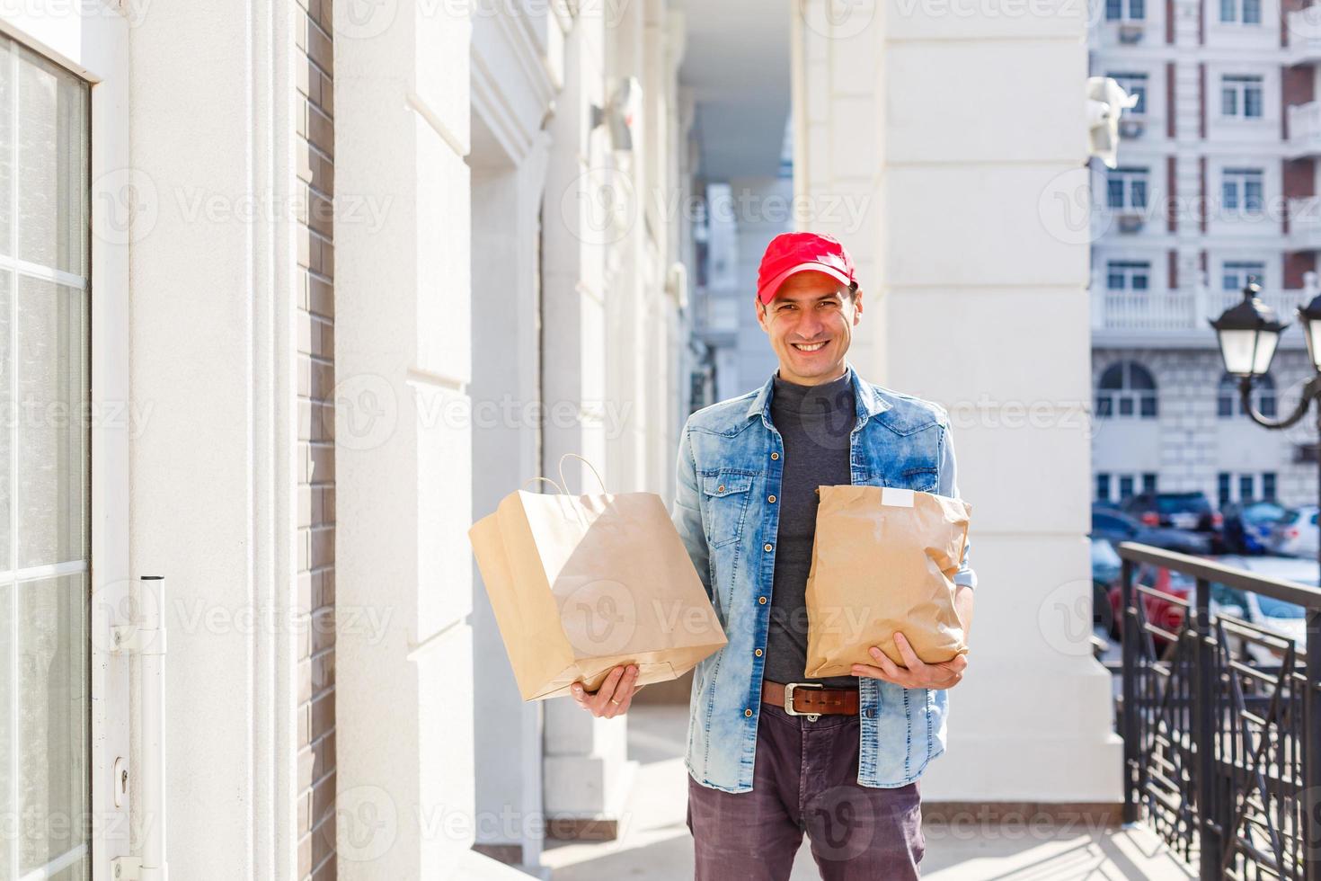 delivery, mail and people concept - man delivering coffee and food in disposable paper bag to customer home photo