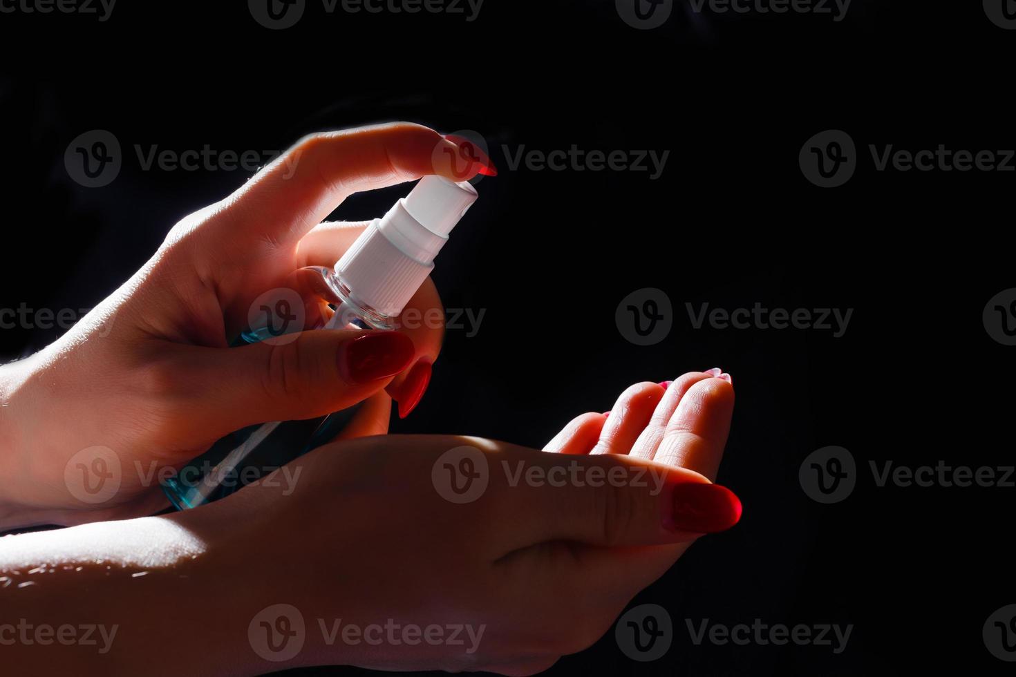 Young girl cleaning hands with alcohol sanitizer photo
