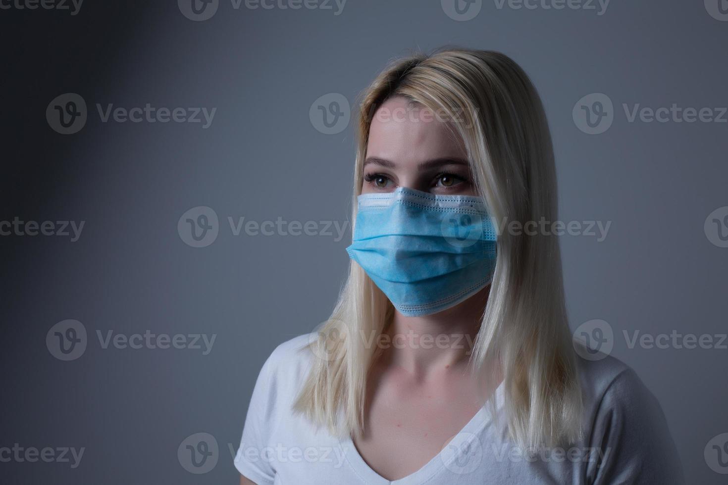 An unhappy woman wearing a face mask to deal with virus or pollution. photo