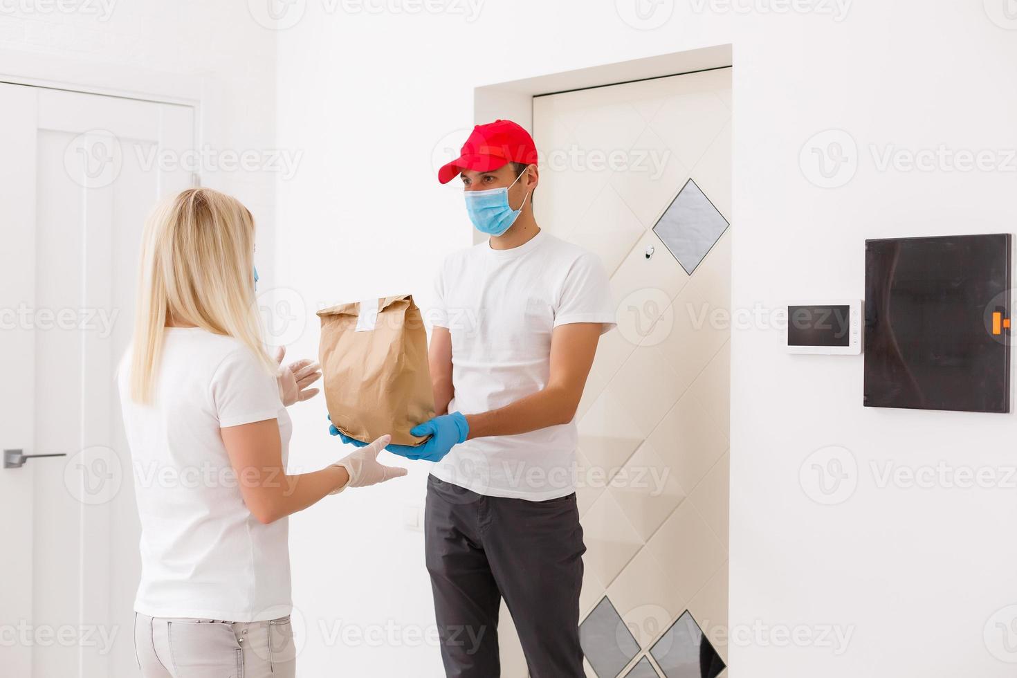 a young girl carefully opens a parcel from a Chinese online store. she uses personal protective equipment gloves and a medical mask as she fears infection with coronavirus photo