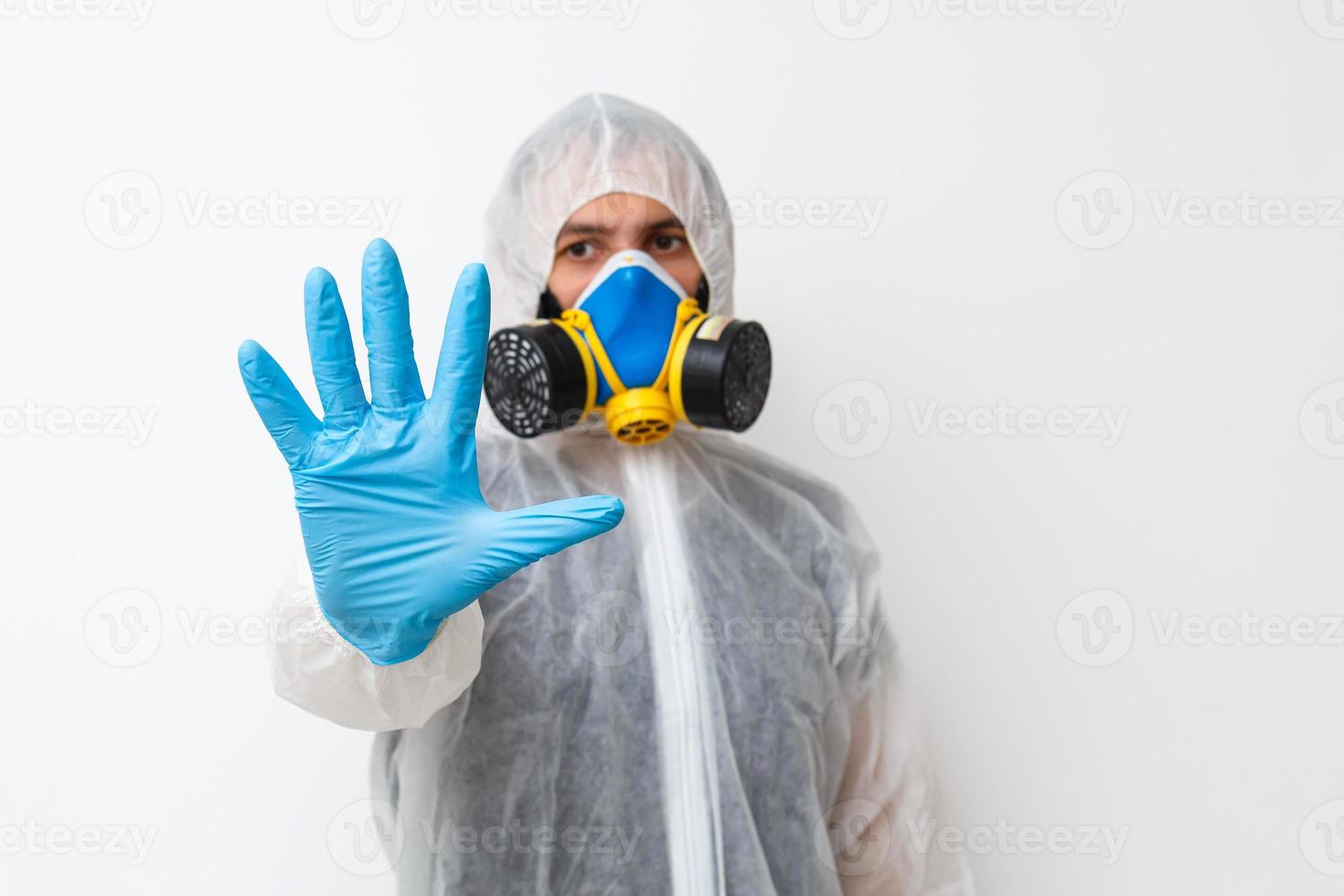 Man in protective clothing and a gasmask on a white background photo