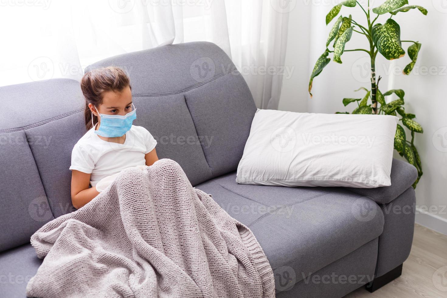 Portrait of sick little girl with runny nose suffering from cold or flu while lying in bed at home. Virus disease. Coronavirus concept. Healthcare concept photo