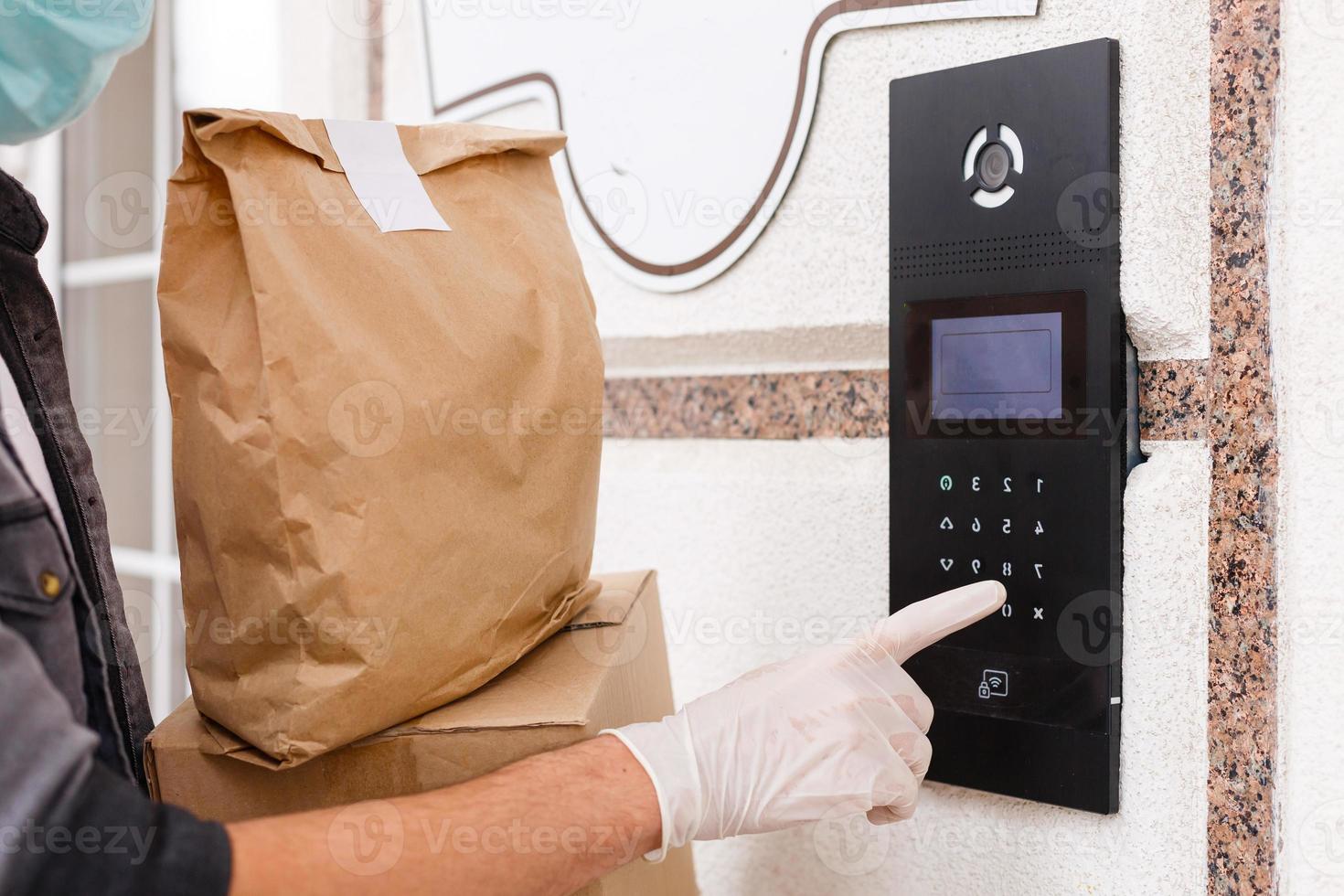 Courier's hands in latex white medical gloves deliver parcels in brown cardboard boxes to the door during the epidemic of coronovirus,COVID-19.Safe delivery of online orders during the epidemic. photo