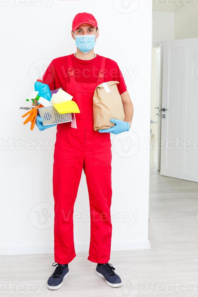 man wearing protection mask and holding basket with cleaning supplies, on white background photo