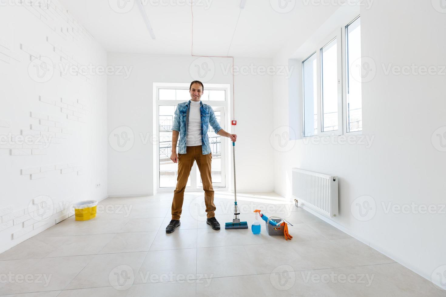 portrait of man with cleaning equipment cleaning the house photo