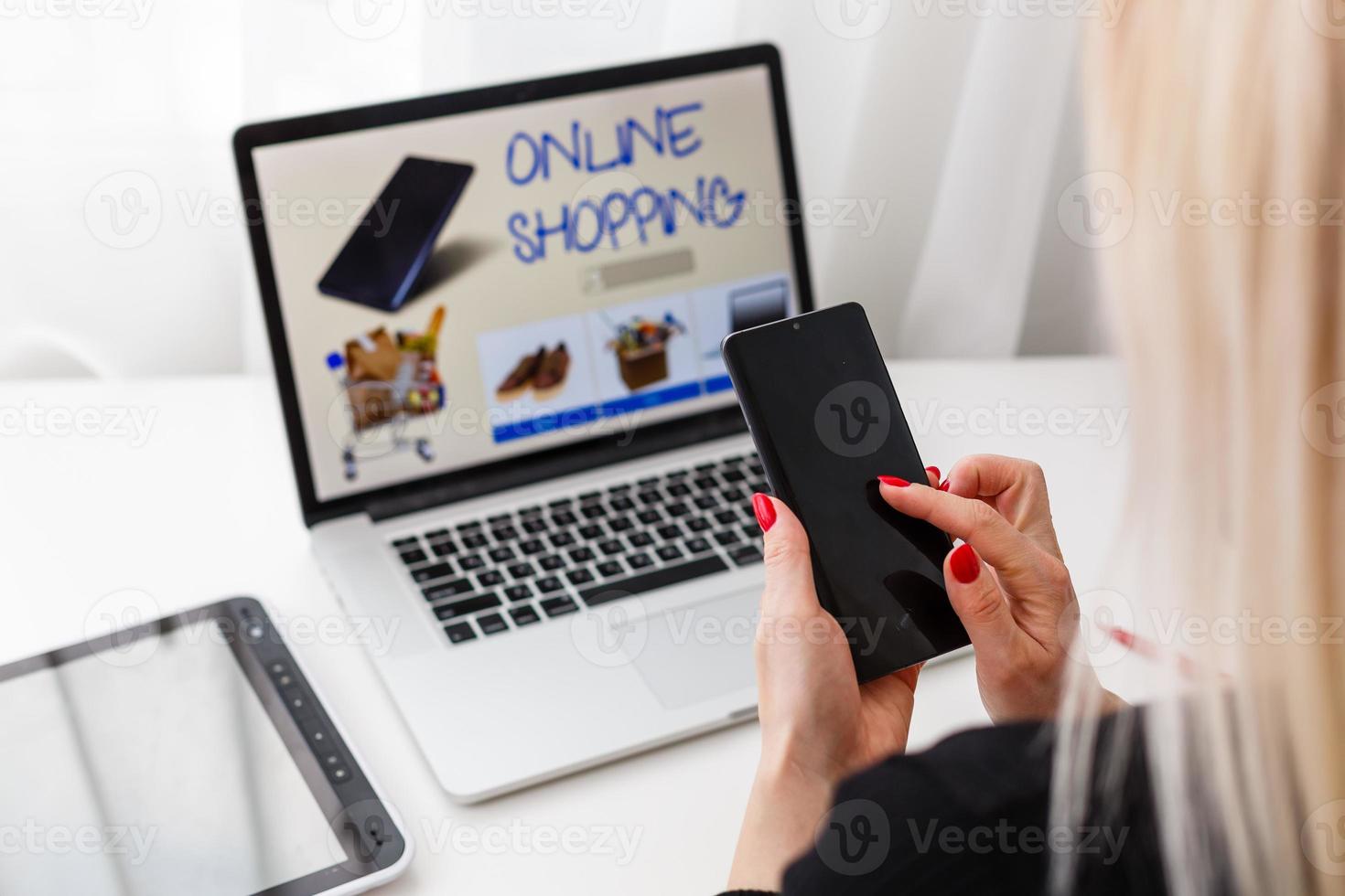 Woman shopping online using her laptop at home photo