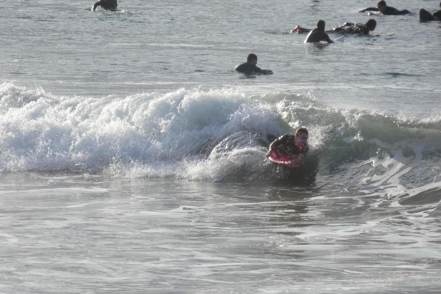 Surfers riding small ocean waves photo